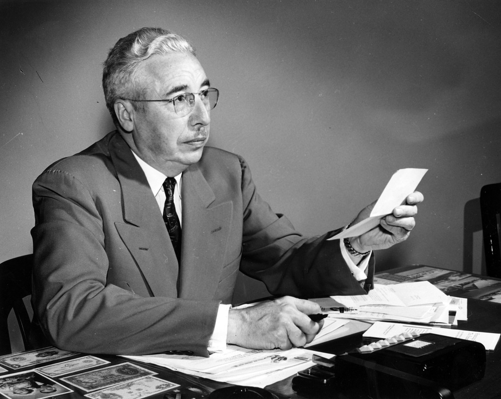Doctor George D. Strohm Sitting At Desk