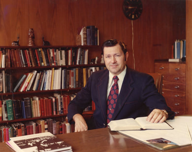 Doctor Francis W. Grubbs Sitting at Desk